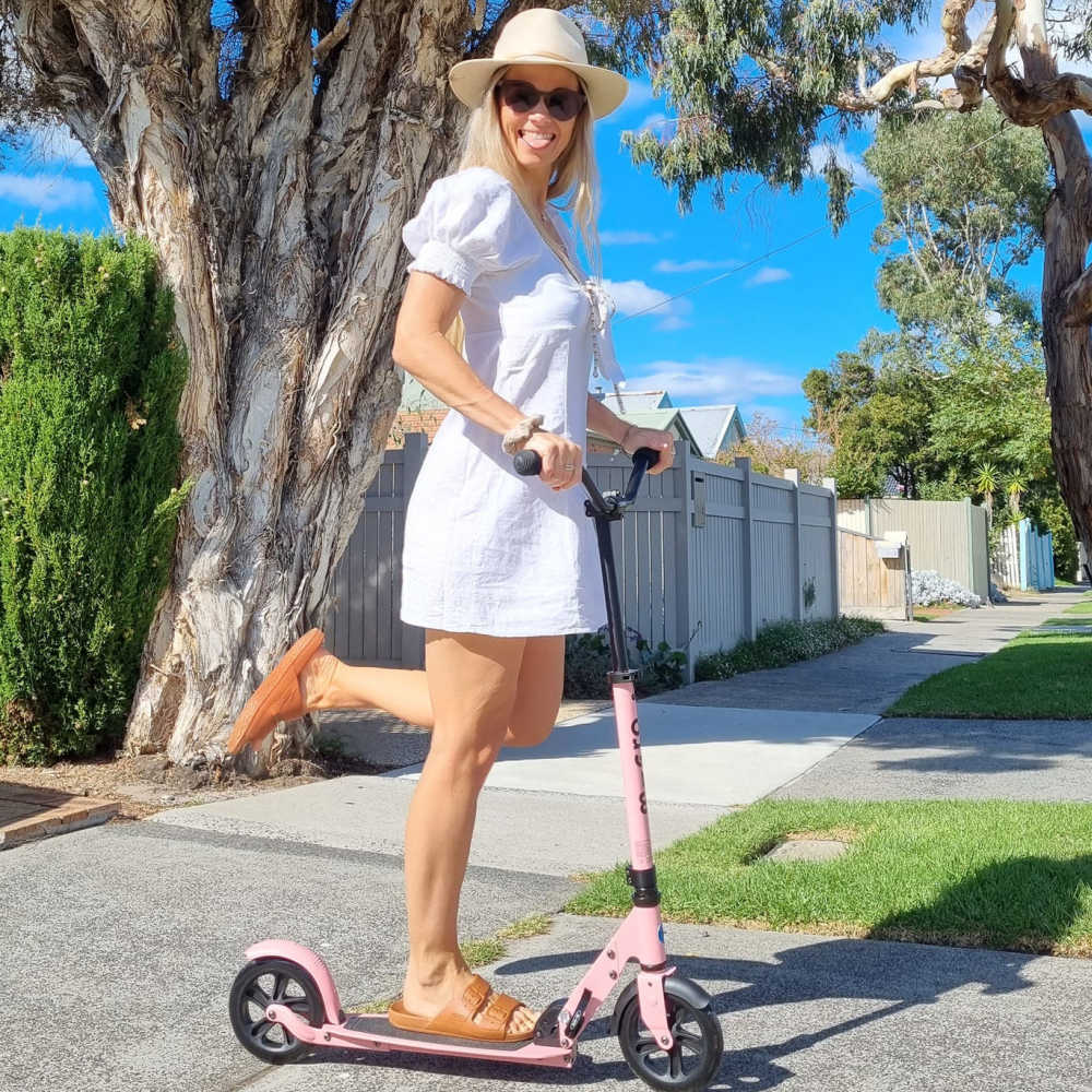 Micro-Speed-Deluxe-Scooter-Woman-On-Her-Neon-Rose