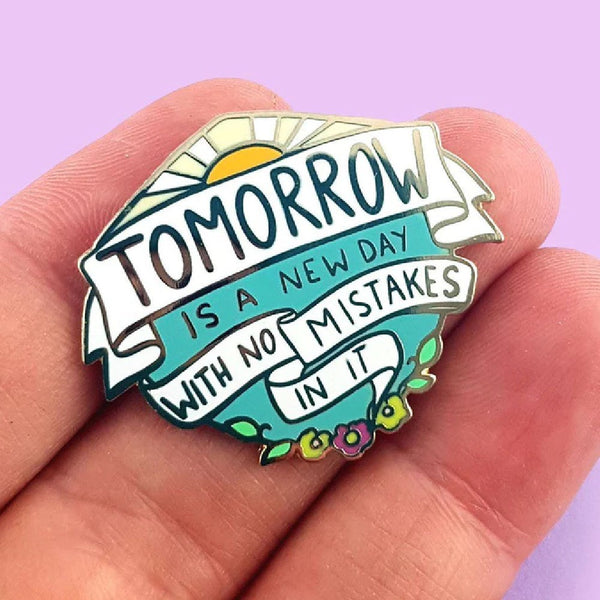 JUBLY-UMPH-Tomorrow-Is-A-New-Day-Lapel-Pin-between-fingers